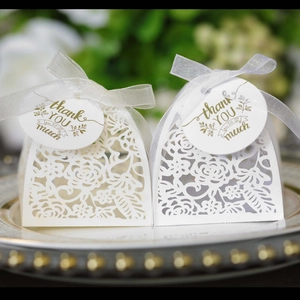 Laser-cut white floral wedding favor box with white ribbon and thank you tag decoration