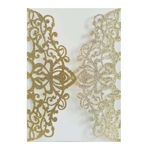 Macro detail of laser-cut floral pattern with golden glitter on wedding invitation