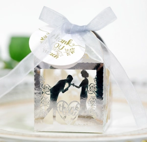 Macro shot of silver hollowed wedding favor box with ribbon and floral thank you tag