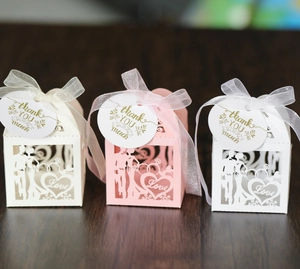 Macro detail of laser-cut wedding favor boxes with ribbon and thank you tags