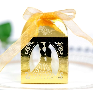 Detailed laser-cut gold wedding favor box featuring silhouette and elegant ribbon bow