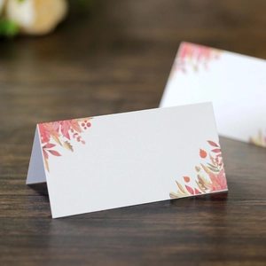 Detail view of foldable place cards with autumn maple leaves on textured paper