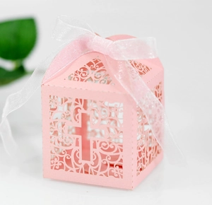Detailed laser-cut vine patterns and cross design on pink candy gift box with white ribbon
