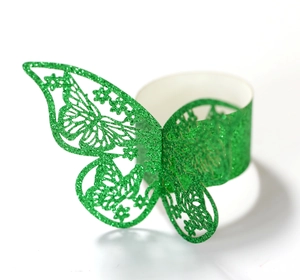 Detalle de un servilletero de mariposa con purpurina verde y patrones florales calados