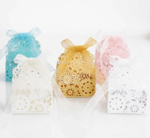 Détails de boîtes à dragées découpées au laser avec des motifs floraux et rubans en satin