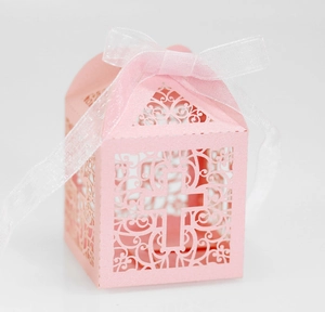 Detail showing laser-cut pink pearlescent candy box with vine pattern and ribbon