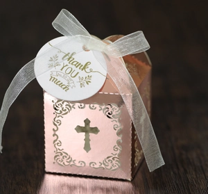 Détail de la boîte à bonbons croix ajourée or rose avec ruban et étiquette