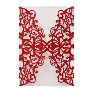 Detail of red glitter wedding invitation laser-cut with intricate floral hollow patterns