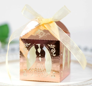 Close-up of laser-cut wedding candy box with bride and groom silhouette and ribbon