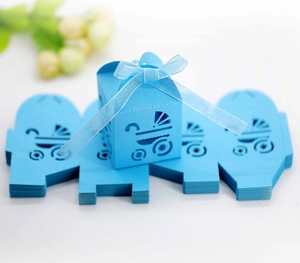 Macro detail of laser-cut baby carriage candy box in sky blue with ribbon bow