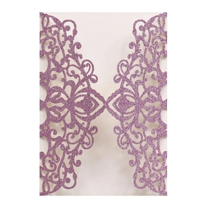 Macro shot of laser-cut glitter paper wedding invitation with intricate floral lace detail
