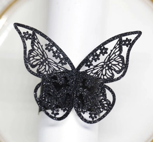 Detalle de un servilletero de mariposa con purpurina negra cortada con láser