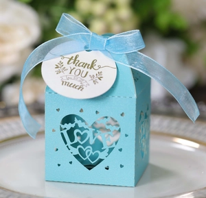 Detail der hellblauen LOVE-Süßigkeitenbox mit Schleife und Dankeschön-Anhänger auf Porzellanteller