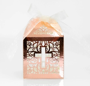 Macro view of rose gold hollow cross candy box with white organza ribbon bow