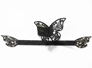 Detalle de servilletero de mariposa calado con láser en papel negro brillante de boda