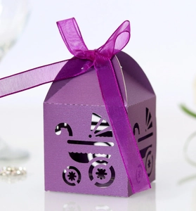 Detail showing laser-cut purple baby carriage favor box with a matching ribbon bow