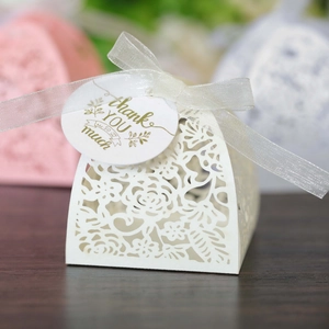 Detail of laser-cut hollow floral gift box with white ribbon and thank you tag