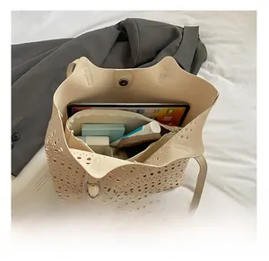 Intérieur spacieux du sac cabas blanc ajouré montrant l'espace pour tablette et maquillage