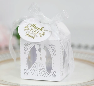 Laser-cut white wedding favor box with bride and groom silhouette and ribbon detail