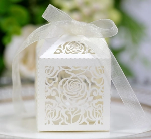 Detailed laser-cut rose pattern on pearl white wedding favor box with ribbon tie