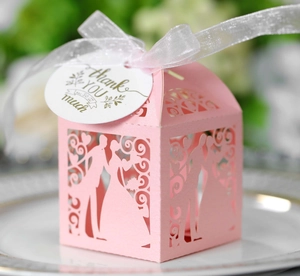 Gros plan d'une boîte de mariage rose découpée au laser avec silhouette et étiquette merci