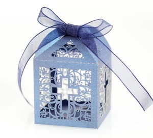 Detail of light blue laser-cut favor box with cross pattern and blue silk ribbon bow