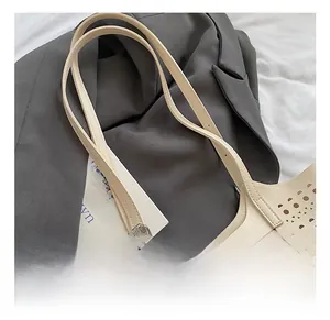 Détail des motifs géométriques découpés au laser et des lanières de ce sac blanc chic