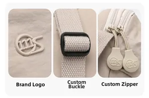 Detail of adjustable strap buckle and logo zipper on a beige nylon crossbody saddle bag
