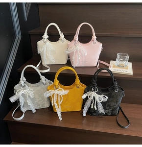 Détail de cinq mini sacs seaux avec poignées nouées et breloques en dentelle et perles