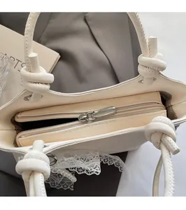 Détail de la fermeture éclair et des finitions en dentelle perlée du sac ivoire