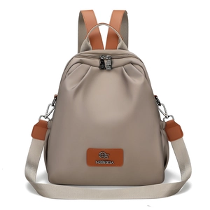 Dettaglio zaino in nylon beige chiaro con manico in pelle marrone e logo MSSHUILA