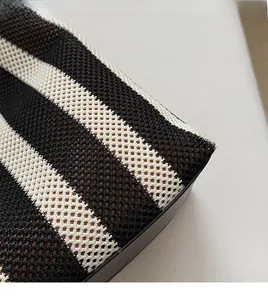 Close-up of black and white striped knitted fabric texture on stylish tote bag