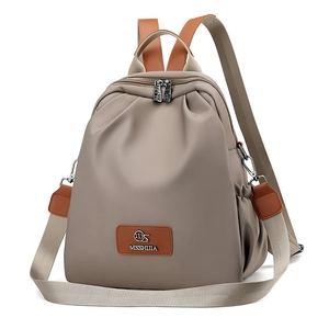 Dettaglio dello zaino in nylon con patch logo in pelle e cerniere in metallo