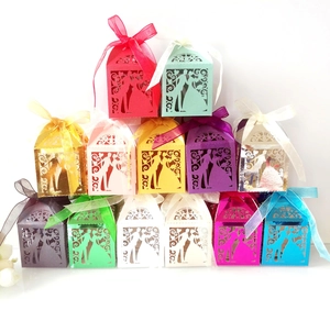 Detail of laser-cut hollow candy boxes with wedding silhouettes and silk ribbons