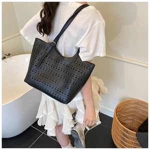 Vue détaillée du sac cabas noir avec motifs découpés circulaires sur cuir souple