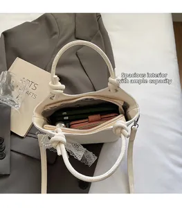 Vue détaillée de l'intérieur spacieux du sac seau crème avec accessoires et dentelle