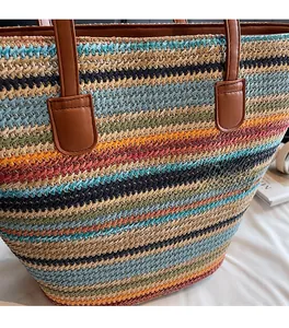 Detailaufnahme der bunt gestreiften Stroh-Tragetasche mit feiner Textur und Lederriemen