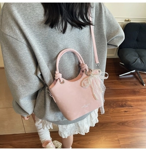 Détail du sac seau rose avec breloque nœud en dentelle et perles avec logo imprimé