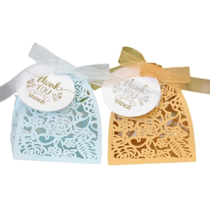 Elegant laser-cut hollow gift boxes with ribbon bows and thank you tags for weddings