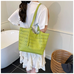 Gros plan d'un sac cabas vert citron ajouré avec motifs circulaires découpés au laser