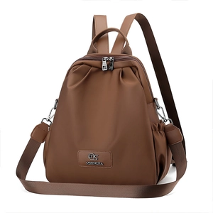 Dettaglio dello zaino in nylon caramello con logo metallico e spallacci rimovibili