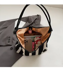 Spacious interior of striped woven tote bag showing storage for daily essentials