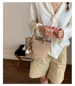 Brown lychee leather handbag with baseball charm and Fashion & Bags printed text