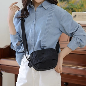 Detail of black nylon saddle bag showing waterproof texture and adjustable shoulder strap