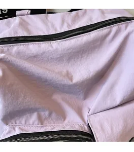 Close-up of lavender travel bag showing soft fabric texture and black metal zipper detail