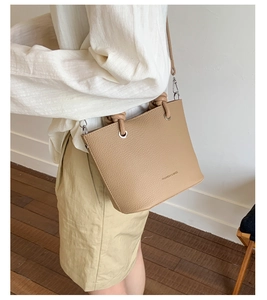 Détail du sac seau en cuir grainé kaki avec poignée nouée et bandoulière