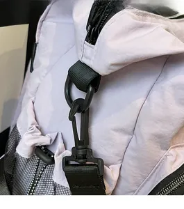 Detail of durable black plastic strap hook and D-ring on light purple nylon outdoor bag