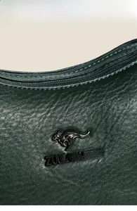 Macro detail of dark green pebbled leather bag with premium metal logo and stitching