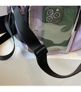 Detail of adjustable shoulder strap and clear phone window on purple travel bag