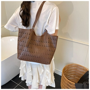 Détail du sac cabas marron ajouré au laser avec bandoulière à boucle argentée chic